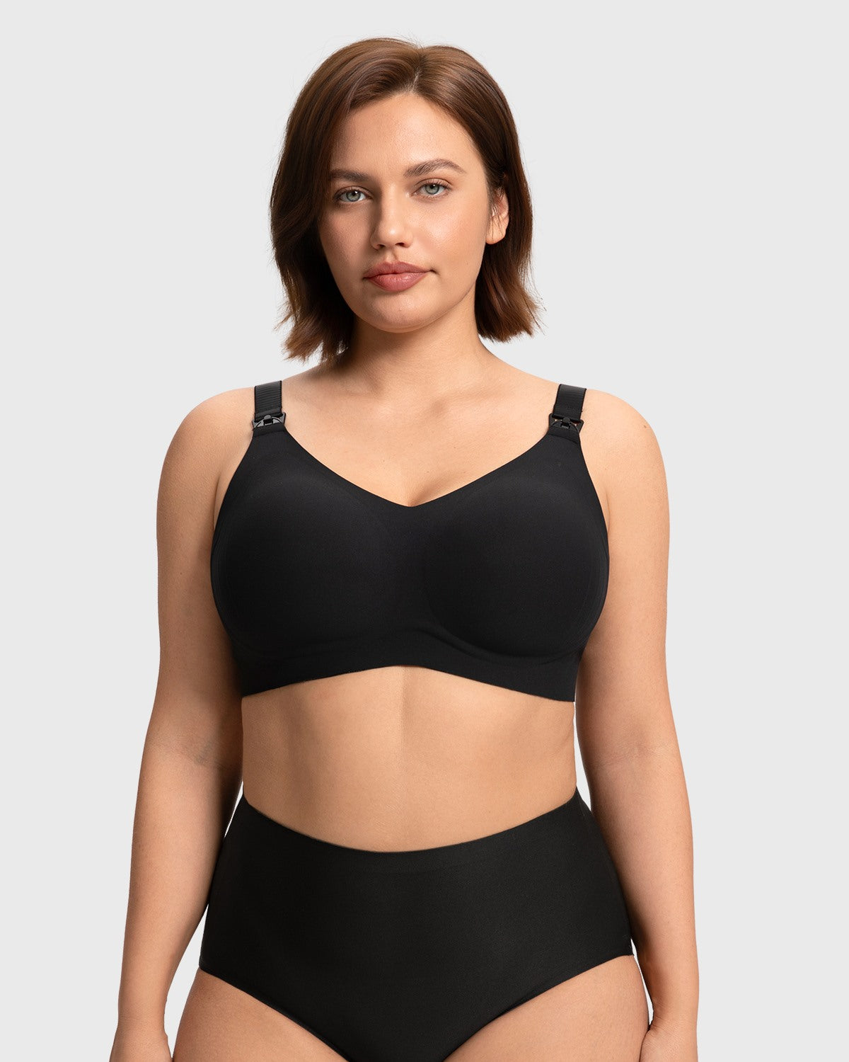 Front view of a model wearing the black SoftContour wireless nursing bra, showing the stylish V-neck design and smooth invisible fit under clothing.