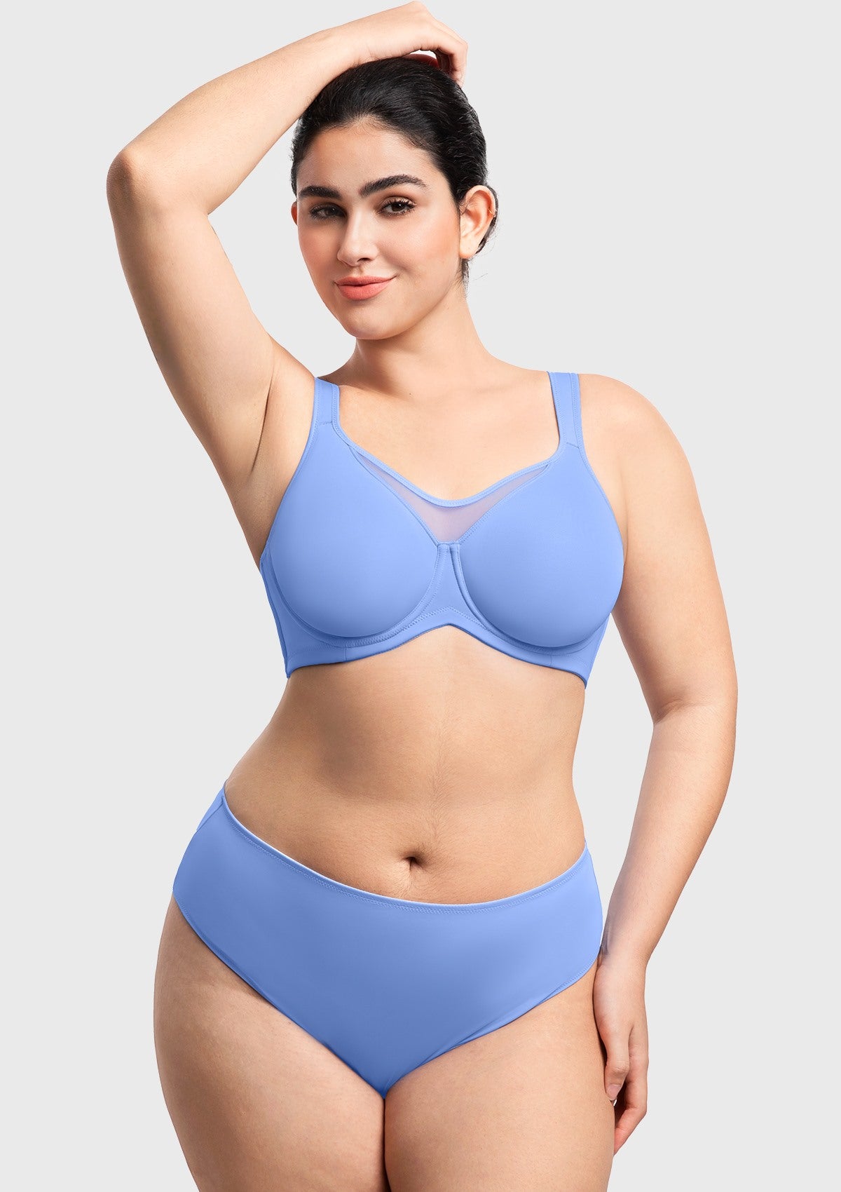 Woman with arms raised wearing the sky blue minimizer bra, ensuring no constant readjusting thanks to the secure, wide underband.
