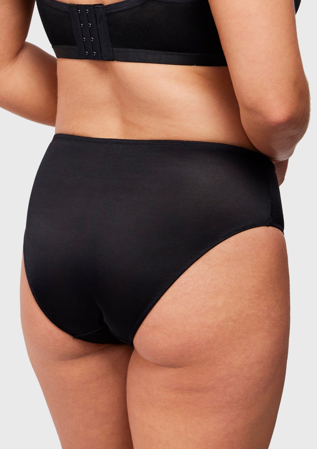  Back view of black Bella sheer mesh bikini on model, showcasing stretch scratch-less fabric that prevents slipping.
