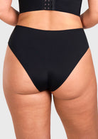 Rear view of model in the black high waist seamless underwear, showcasing full back coverage and no visible panty lines under tight yoga pants.